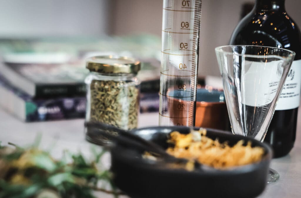 Cylinder glass, herbal bottle, dried plants in a bowl, dried seeds in a bottle