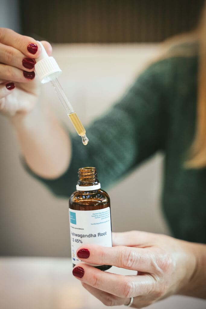 Melinda McDougall, using dropper, pouring liquid in ashwagandha root bottle