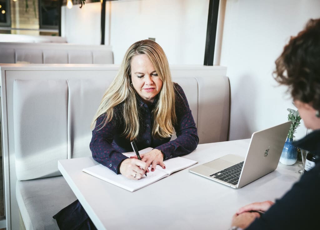 Melinda McDougall, writing prescriptions in a notebook during one on one personal consultation